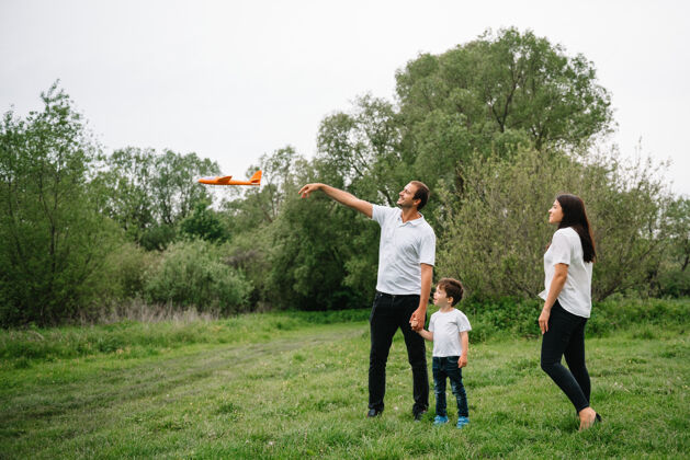 快乐爸爸 妈妈和儿子在公园里玩玩具飞机爸爸父母妈妈