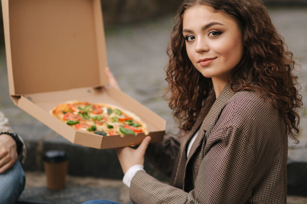 检疫女人在户外打开披萨盒蔬菜坐着男性