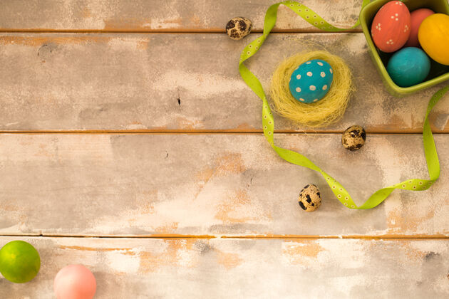庆祝五彩缤纷的复活节彩蛋在一个绿色的盒子和巢木头篮子信仰