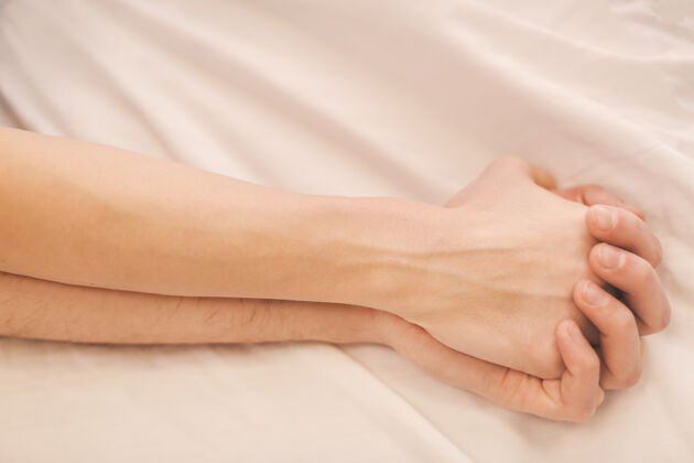 舒适睡在床上的年轻夫妇的手男人舒适手
