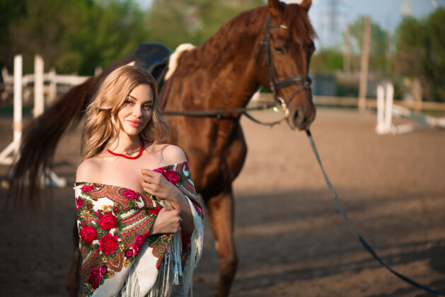 青少年牧场上披着围巾的马和女人护理头发户外