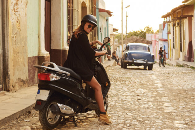 自行车在老城区街道上开着摩托车的女旅行者活动街道旅行