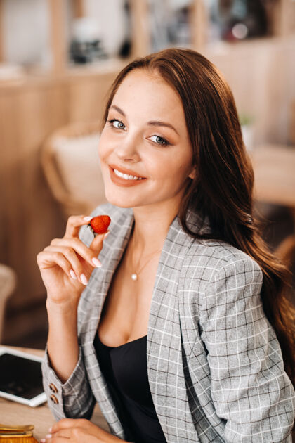 早餐一个女人正坐在咖啡馆里吃草莓甜食模特健康