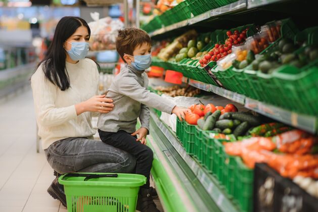 顾客戴着防护面具的母子俩在店里选购水果口罩检疫疾病