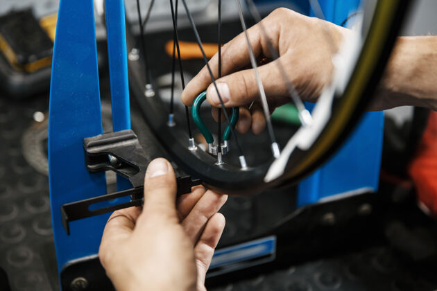工业在修理自行车的车间里 男人把车轮上的辐条拧紧了工人商店修理