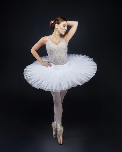 腿迷人的芭蕾舞演员在黑色背景上优雅地摆出姿势平衡脚优雅