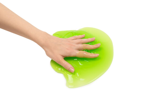 手绿色粘液玩具在女人手上隔离在白色背景上科学小教育