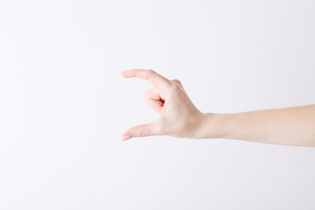 拇指空荡荡的女性手做出的姿势就像拿着白色的东西一样空白手腕采取