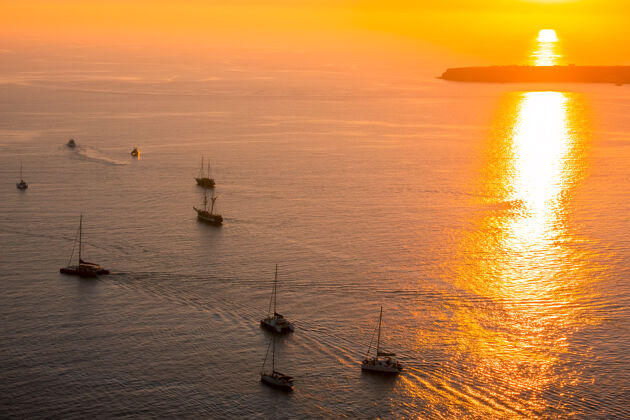 交通红色的日落海.地段帆船和双体船与游客航海旅游游艇