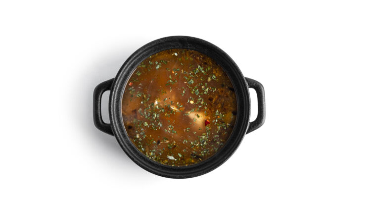 蔬菜在一个白色的表面上孤立的黑锅热汤汤姆百胜配料晚餐