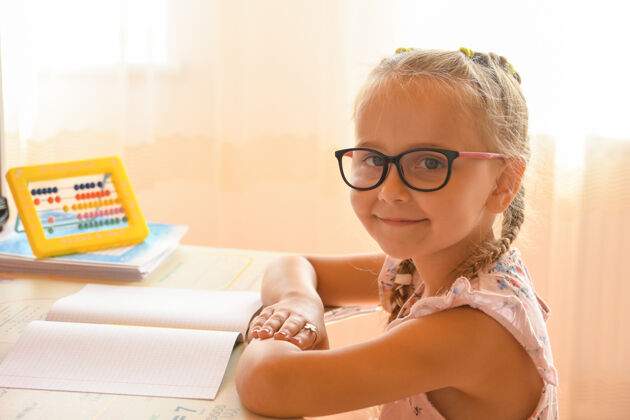 计算机在家学习 一个小女孩戴着眼镜坐在书桌旁的画像快乐女孩小学