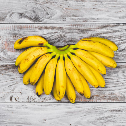 维生素生的有机黄色婴儿香蕉在白色木桌上 俯瞰一串糖素食香蕉