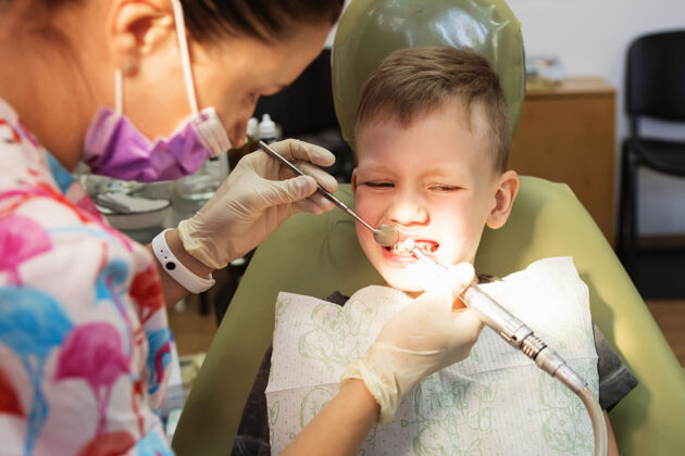 牙医一个小男孩在牙科诊所的牙医招待会上风险龋齿腐烂