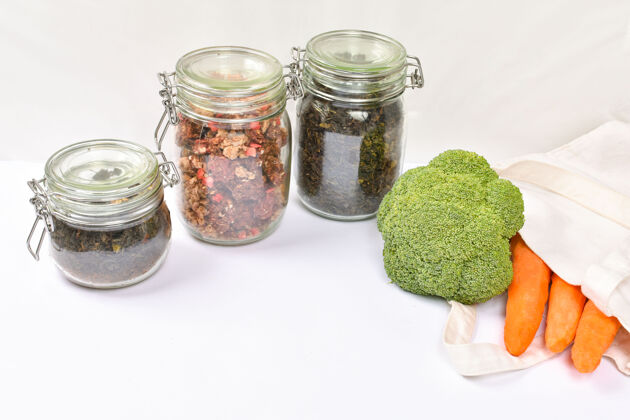 食物新鲜蔬菜放在白墙上环保的米色手提袋里 零浪费概念玻璃干货罐手提包罐子袋子