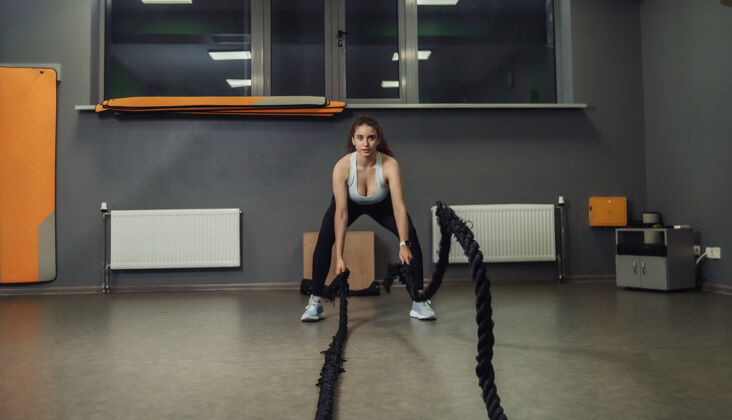 积极年轻健美的女子在训练中用战绳锻炼身体功能类训练 锻炼过程室内生活方式强壮