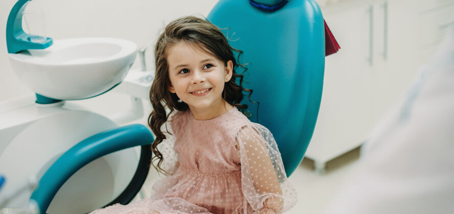 牙科可爱的小女孩看着她的儿科口腔医生微笑着做儿童牙科牙齿检查孩子药物牙齿