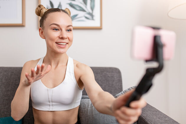 女性快乐的女运动员微笑着做手势 在家里录制健身视频私人教练移动高兴
