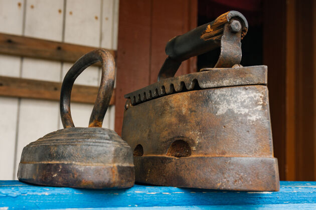 历史的古色古香的木炭铁杆复古木排熨斗货架.旧的时尚熨烫工具.遗产概念电器古董单