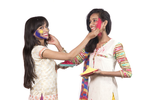 友谊快乐的年轻女孩们在胡里节的彩色粉玩得开心庆祝快乐表情