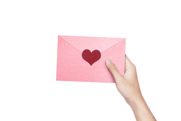 心人的手拿着一个粉红色的信封 心被隔离在白色的墙上节日情人节礼物