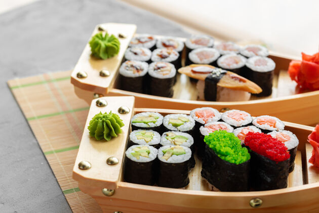 寿司木船托盘上的一套maki寿司特写盘子木头餐桌