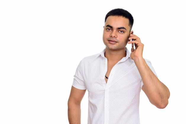 按下年轻英俊的印度男人用手机交谈 与空白隔绝通信移动印度