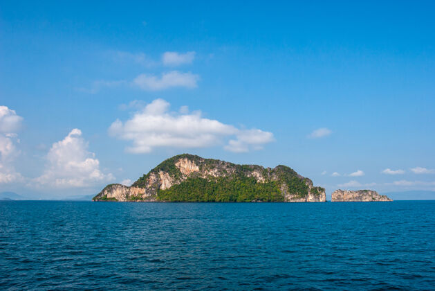 海滩大海中的岩石岛映衬着蓝天天堂阳光风景