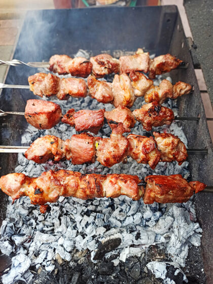 美味肉串在木头上 在街上 烧烤 野餐.猪肉在滚烫的煤的背景下户外火焰烹饪