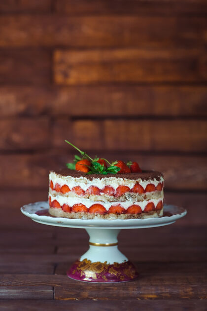 蛋糕木制背景上的草莓蛋糕装饰春天多汁