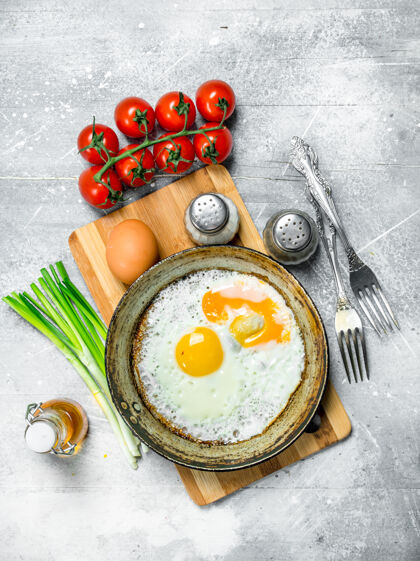 食物在平底锅里煎鸡蛋 加西红柿和葱健康白色饮食