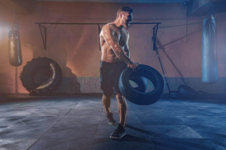 努力健美训练 大胡子强壮的运动员 肌肉发达的身体举起沉重的轮子在健身房轮子健身房体重