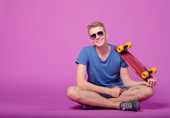 运动紫色背景上手拿滑板的男人青年肖像休闲