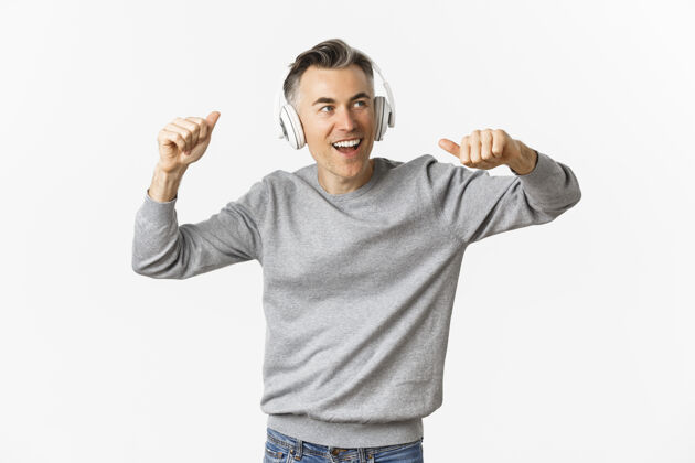 快乐帅哥的肖像 现代的中年男人 戴着耳机听音乐情感耳机积极