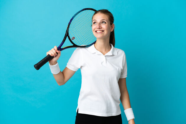 惊奇年轻的女子网球运动员孤零零地站在蓝色的一边抬头思考着一个想法表达思考成年人