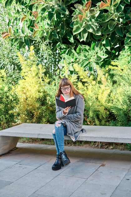 女人一个蓝眼睛的白人金发女郎戴着眼镜在公园看书女孩教育阅读