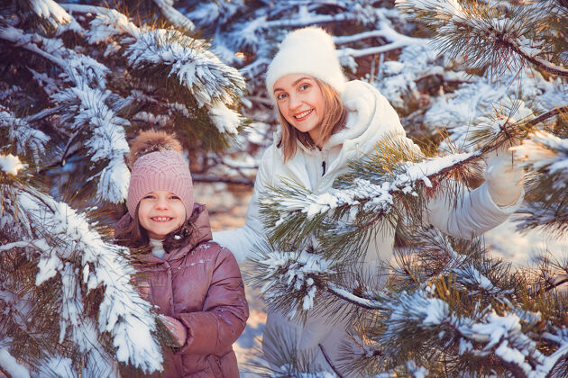 白种人妈妈和女儿在冬季公园玩得很开心成人散步公园