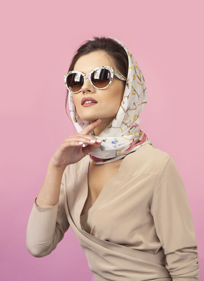 工作室前面的肖像是一个优雅的年轻女子穿着优雅的衣服 复古的太阳镜头巾模特优雅