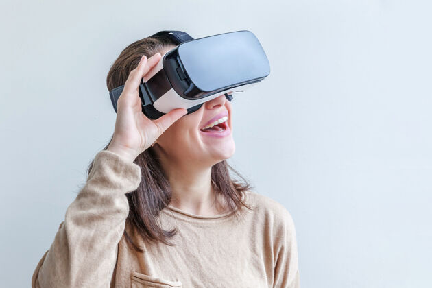 3d微笑的年轻女子戴着虚拟现实vr眼镜头盔耳机在白色背景上想象设备体验
