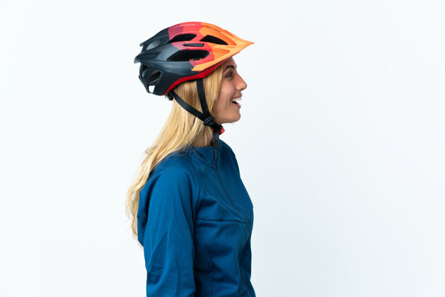 人年轻的金发乌拉圭骑自行车的女人笑在横向位置女人自行车手头盔