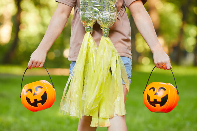孩子女孩背着南瓜袋在户外散步的特写镜头叶子季节幽灵