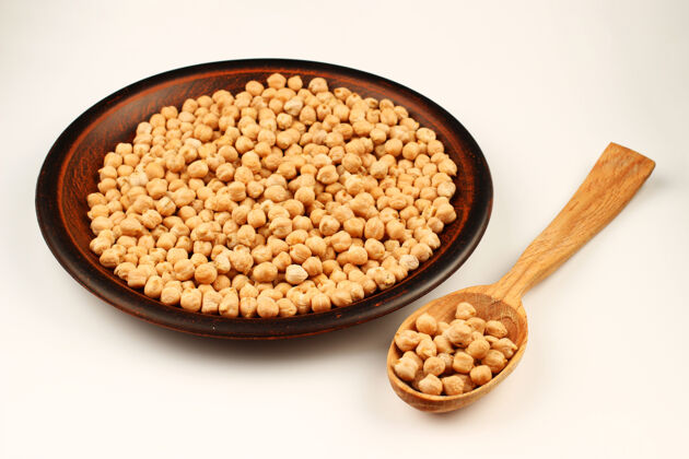 素食鹰嘴豆放在盘子里 勺子放在白色的表面上蛋白质豆类谷物