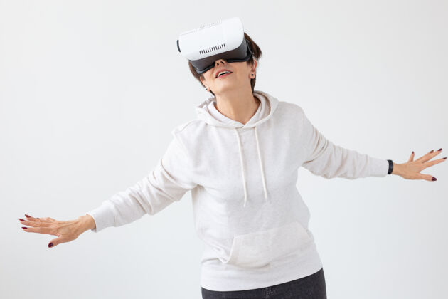 肖像穿着轻便毛衣的中年妇女戴着虚拟现实的眼镜玩一个d游戏活跃白种人清新