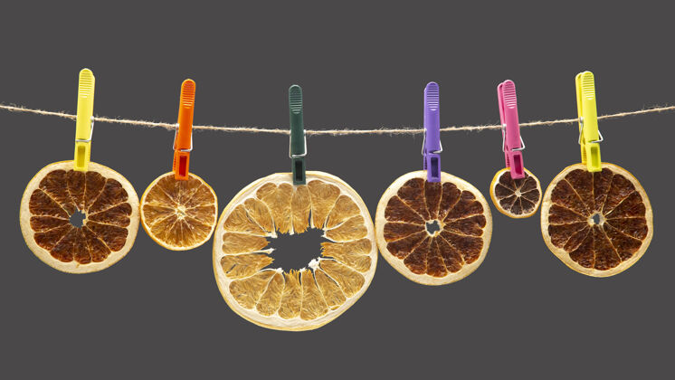 花环不同柑橘类水果的干片挂在彩色的衣夹上口味维生素夹具