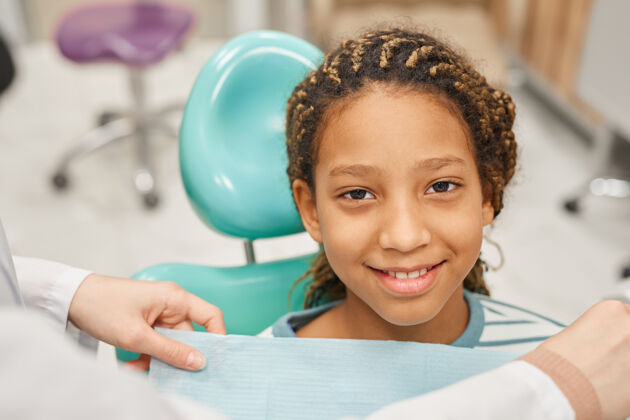 人脸坐在椅子上看牙医的小女孩微笑的画像健康的生活方式诊所童年