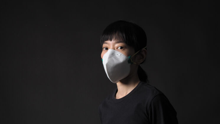 亚洲人一个戴着黑色面具的亚洲女孩在冠状病毒检疫的情况下女人医学防护