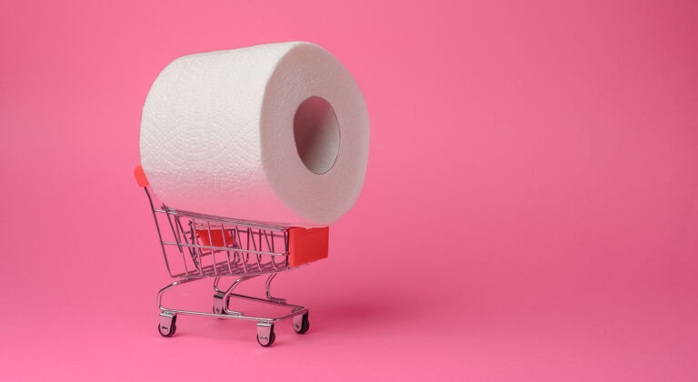 流行病上班期间抢购卫生纸隔离卷把卫生纸放在玩具手推车里放在粉红色的椅子上背景关闭-起来超市市场大流行