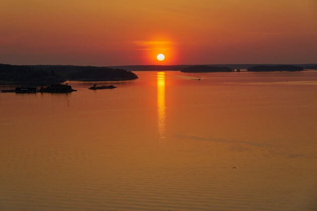 日出纳坦塔利的金色夕阳 芬兰.反思太阳落在地上水副本空间黄昏放松海洋