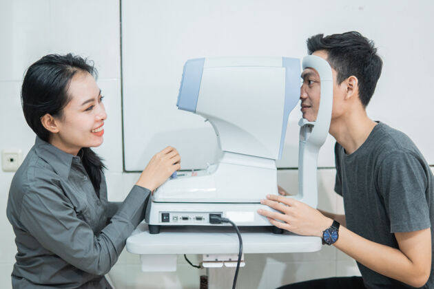 视力一个女医生和一个男病人在眼科诊所用仪器做眼科检查医学测试医生