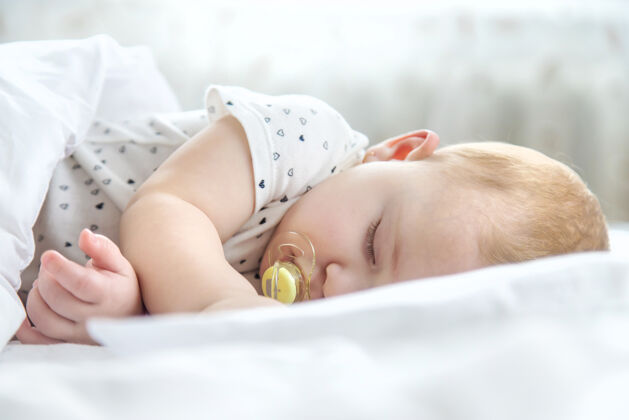 新生儿宝宝睡在白色的床上就寝时间年轻童年
