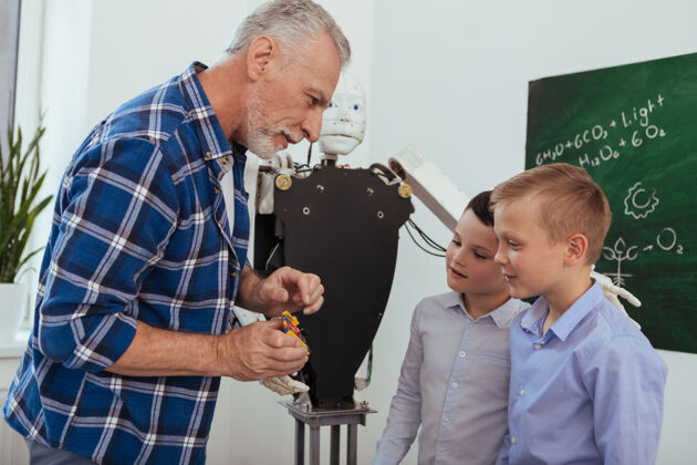 童年科学老师快乐的老人一边给学生讲科学一边和他们交谈世代经验科学
